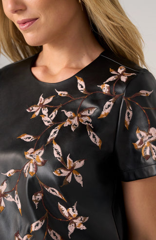 Close view of floral embroidery on Liverpool black faux leather top