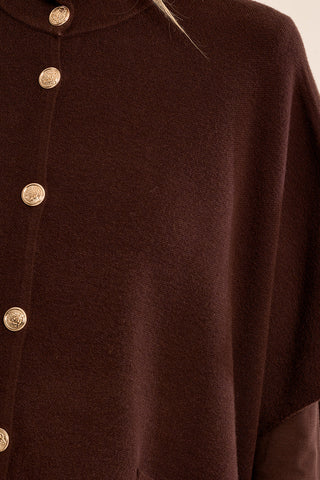 Close view of brown knit fabric and decorative metal snap fastenings